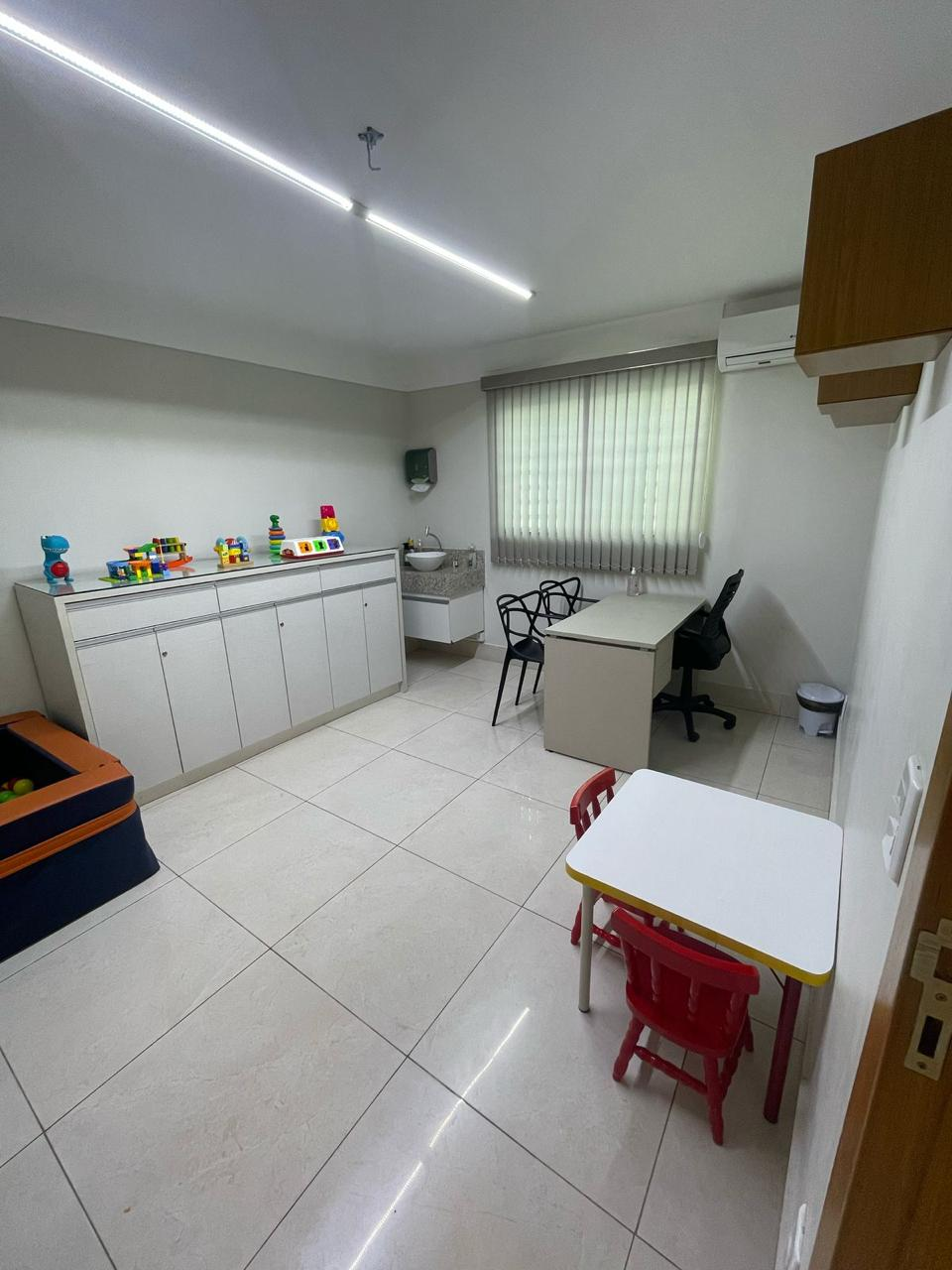 Consultório amplo do Alecrim com bancada de brinquedos, mesa infantil e mesa de trabalho