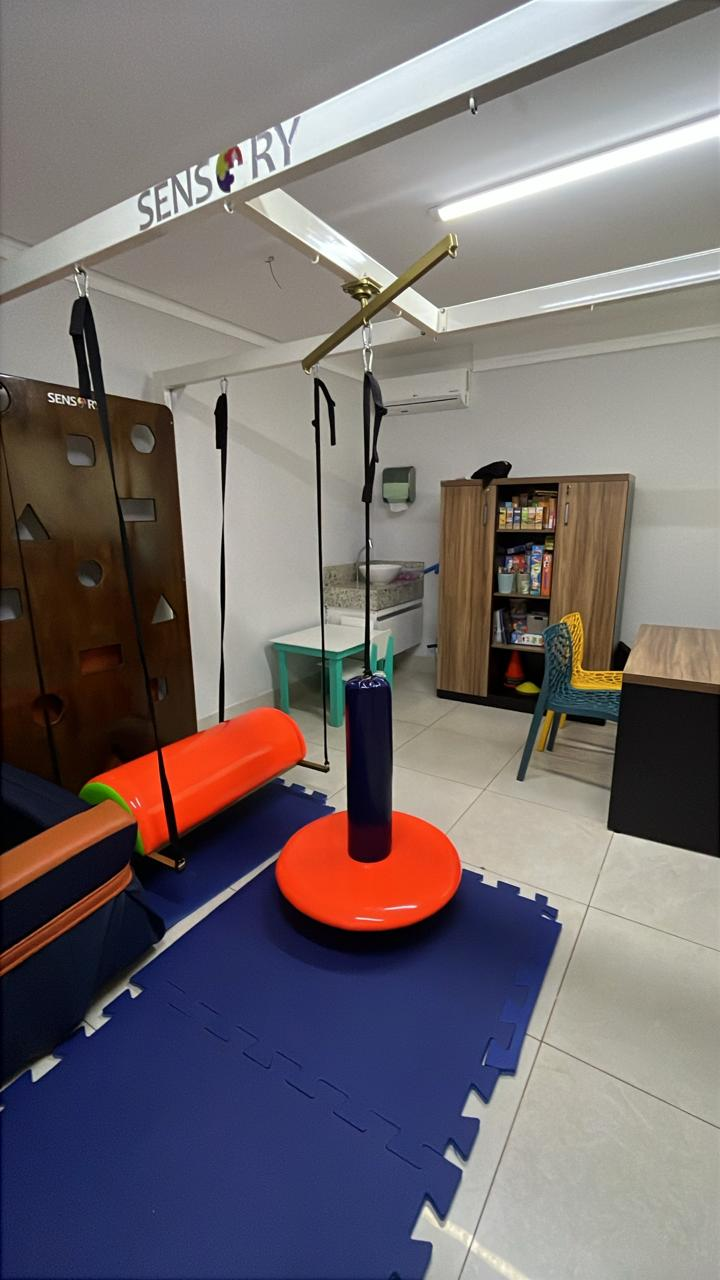 Sala de integração sensorial do Alecrim com estrutura de balanços, tapetes de espuma e painel sensorial