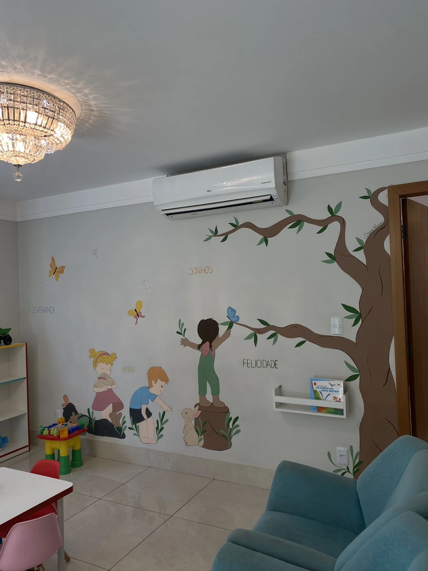 Mural pintado à mão na brinquedoteca do Alecrim com árvore e palavras Esperança, Fé, Amor, Sonhos e Felicidade
