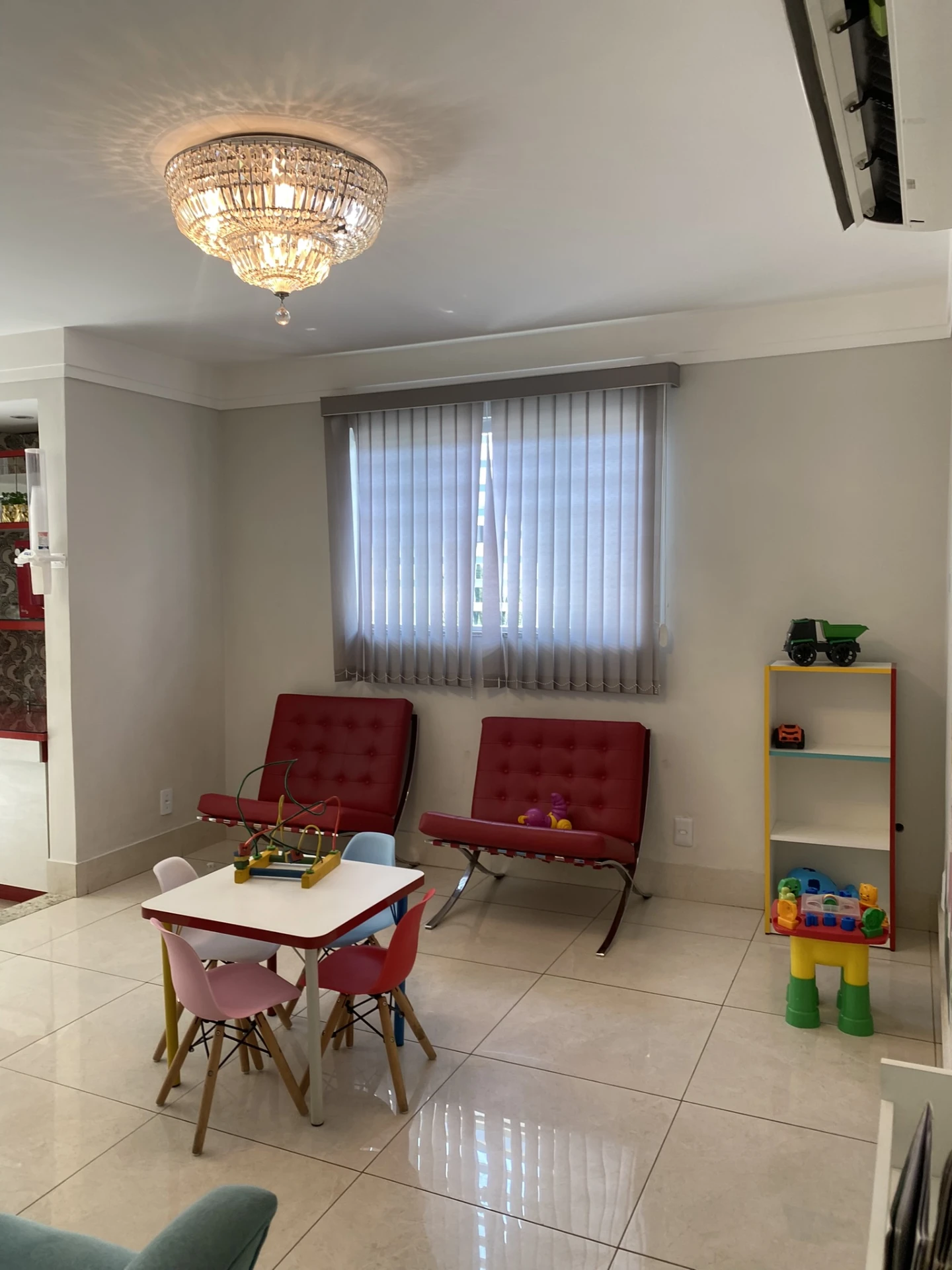 Brinquedoteca do Alecrim com mesa colorida, cadeiras infantis e estante de brinquedos