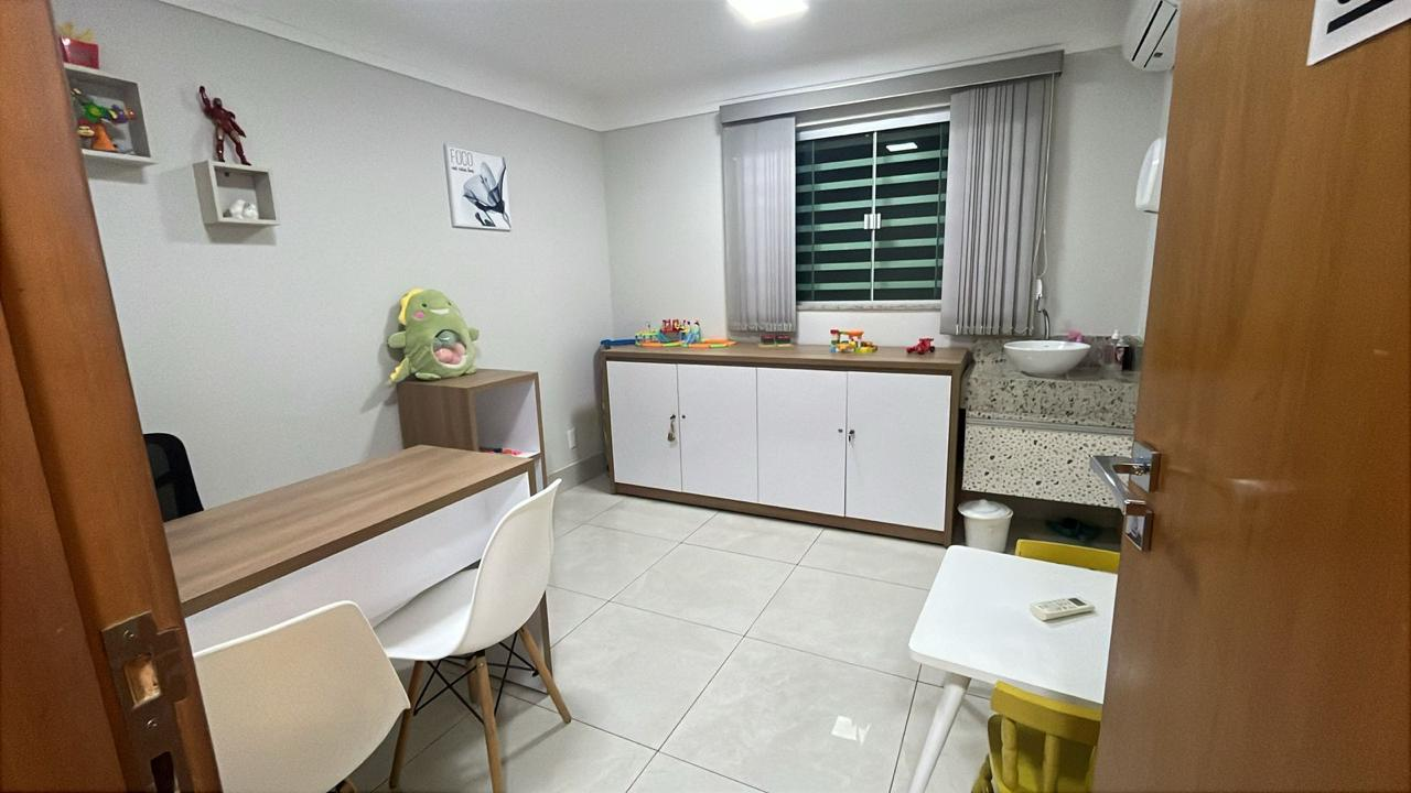 Consultório lúdico com nichos de brinquedos, mesa de atividades e bancada